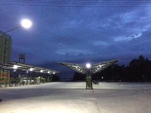An outdoor parking area with a covered structure and a street lamp. - River Residence 2 (Saraburi)