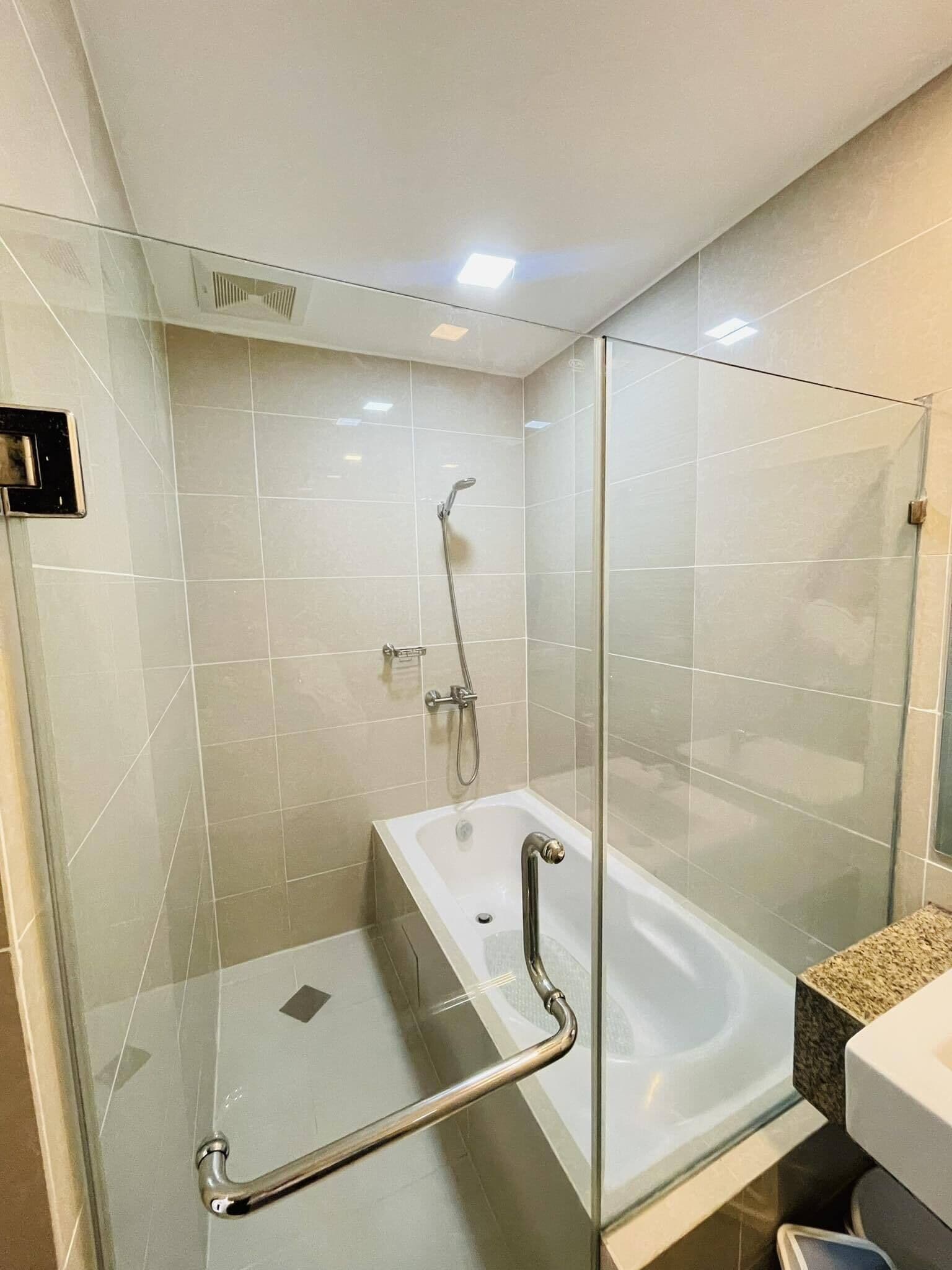 Une salle de bain moderne avec une douche à parois de verre, une baignoire blanche et un comptoir en granit.