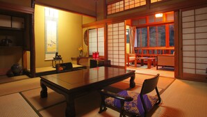 A traditional Japanese room with tatami flooring, a low table, and sliding doors. - Ryokan Ohashi (Misasa)