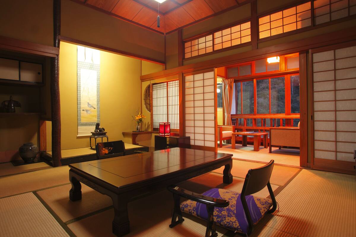 A traditional Japanese room with tatami flooring, a low table, and sliding doors.