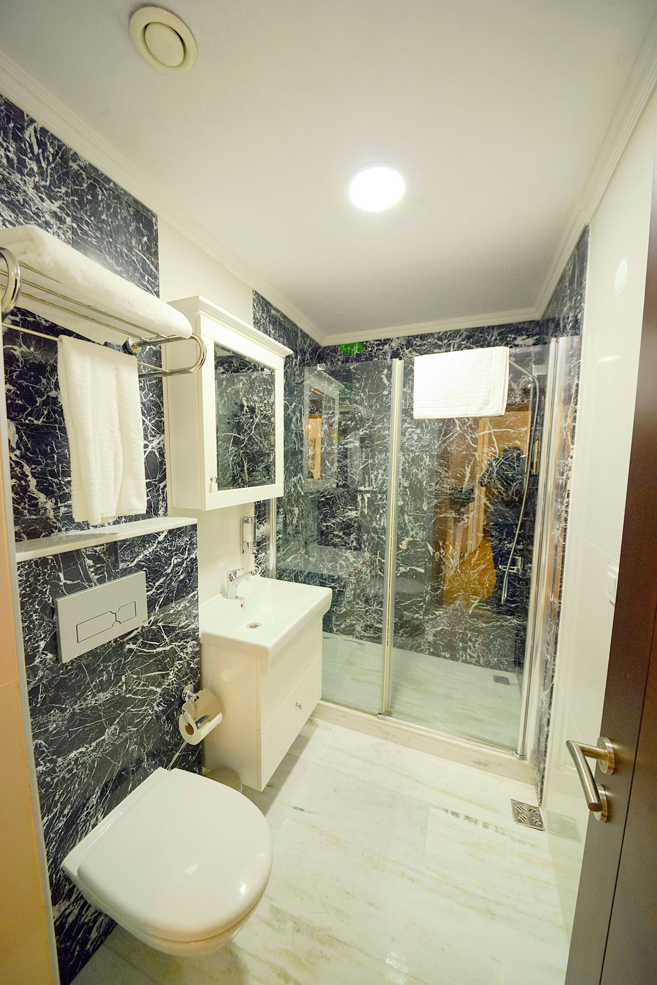Un baño moderno con inodoro, lavabo y zona de ducha.