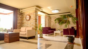 A spacious lobby with a marble floor, a reception desk, and seating areas with sofas and armchairs. - Sarajevo Suit Hotel (Cayirova)