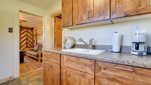 A kitchen with wooden cabinets, a granite countertop, a sink, a coffee maker, and a microwave. - 'Hiawatha' Peaceful Living in Rocky Mtn Nat'l Park (Allenspark)