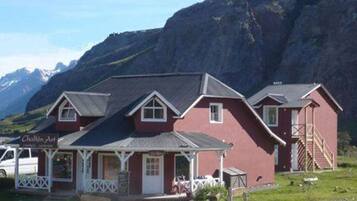 A red building with a porch and a sign that reads "Chalet Art".