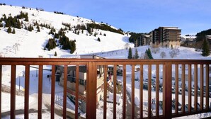 A snow-covered mountain with a ski resort, including buildings and a parking area. - Cozy Chalet for You & Tails (Auris)
