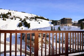 A snow-covered mountain with a ski resort, including buildings and a parking area. - Cozy Chalet for You & Tails (Auris)