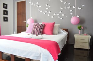 A bedroom with a bed, pillows, a nightstand, and decorative butterflies on the wall. - Chalet Familiar (Montenegro)
