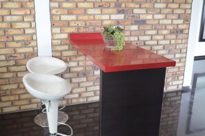 A restroom with two white sinks, a red countertop, and a vase with green grapes. - Chalet Familiar (Montenegro)