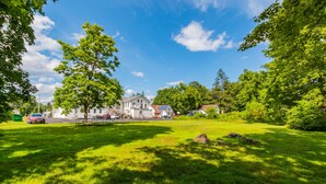 A residential area with a large house, a lawn, and a tree. - Historic Hotel Broadalbin (Broadalbin)
