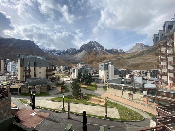 Un moderno complejo hotelero con varias edificaciones, un patio central y vistas a las montañas.