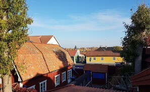 A red building with a sloped roof, a yellow building with a red roof, and a green building with a white roof in a residential area. - Hotell Klockargården (Öregrund)