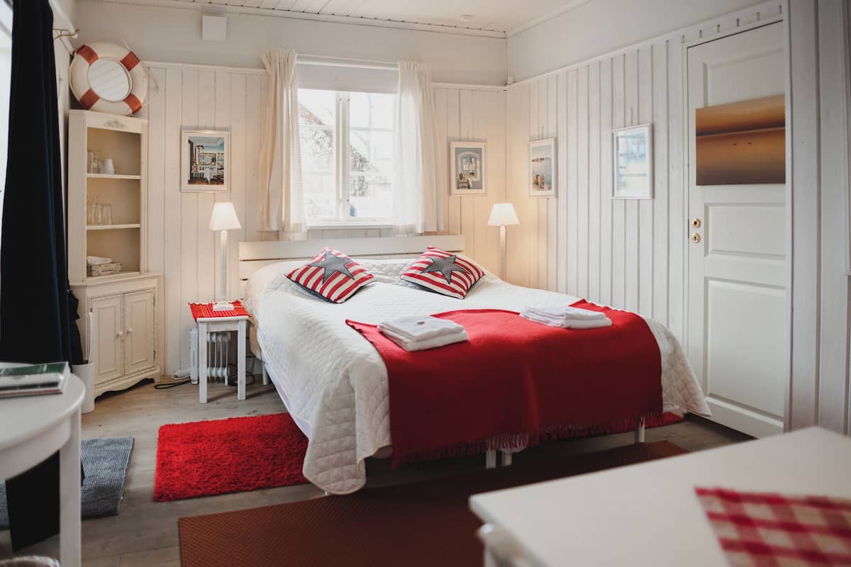 A neatly arranged bedroom with a bed, bedside tables, a window, and a door.