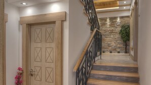 Una escalera de madera con un muro de piedra y una planta en maceta.