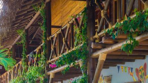 A wooden structure with bamboo supports and green vines.