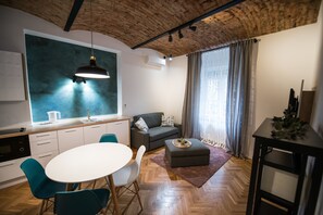 A modern living space with a kitchen, dining area, and seating area.