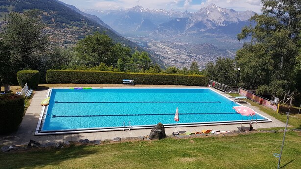 A swimming pool with a view of mountains in the background.