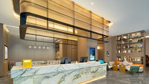 A modern reception area with a marble counter, seating, and a well-lit interior. - Yizhi Hotel Rainbow Bridge Subway Gz (Guangzhou)