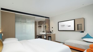 A modern hotel room with a large bed, a desk, a chair, and a small sofa. - Yizhi Hotel Rainbow Bridge Subway Gz (Guangzhou)