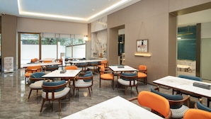 A modern dining area with marble-topped tables and chairs, large windows, and a clean, well-lit interior. - Yizhi Hotel Rainbow Bridge Subway Gz (Guangzhou)