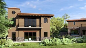 Une maison moderne à deux étages, dotée d’un balcon, de grandes fenêtres et de fondations en pierre.