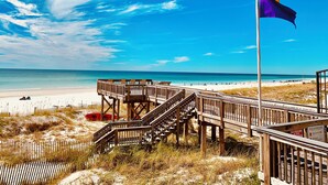 A wooden boardwalk leading to a beach with a flagpole and a beach warning sign. - Beautiful beachfront condo with Stunning Gulf Views!! 4061 BS1 (Miramar Beach)