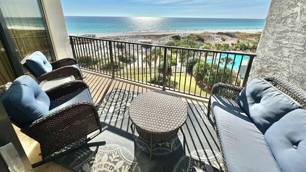 A balcony with wicker furniture, a small round table, and a view of the ocean and beach. - Beautiful beachfront condo with Stunning Gulf Views!! 4061 BS1 (Miramar Beach)