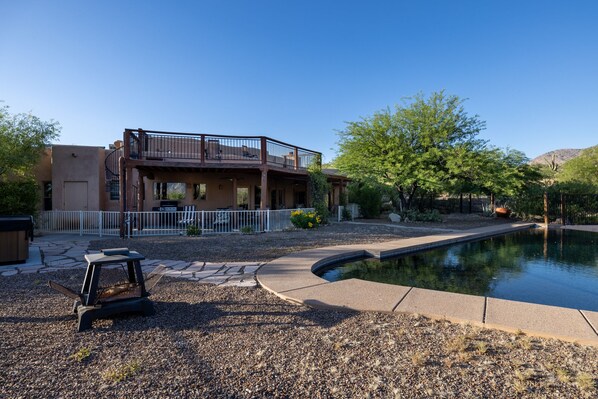A two-story house with a balcony, a swimming pool, and a patio area with a grill and seating. - Mountain Getaway, Tranquility, Beauty, Ambience, Stunning View (Tucson)