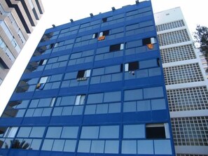 Un moderno edificio a grattacielo con facciata blu e numerose finestre.