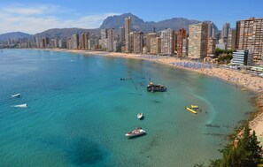 A coastal cityscape with a beach, boats, and high-rise buildings. - Lido (Benidorm)