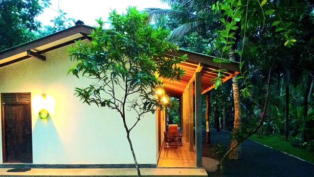 Ein Haus mit einer Veranda, einem kleinen Garten und einem Weg zum Eingang.