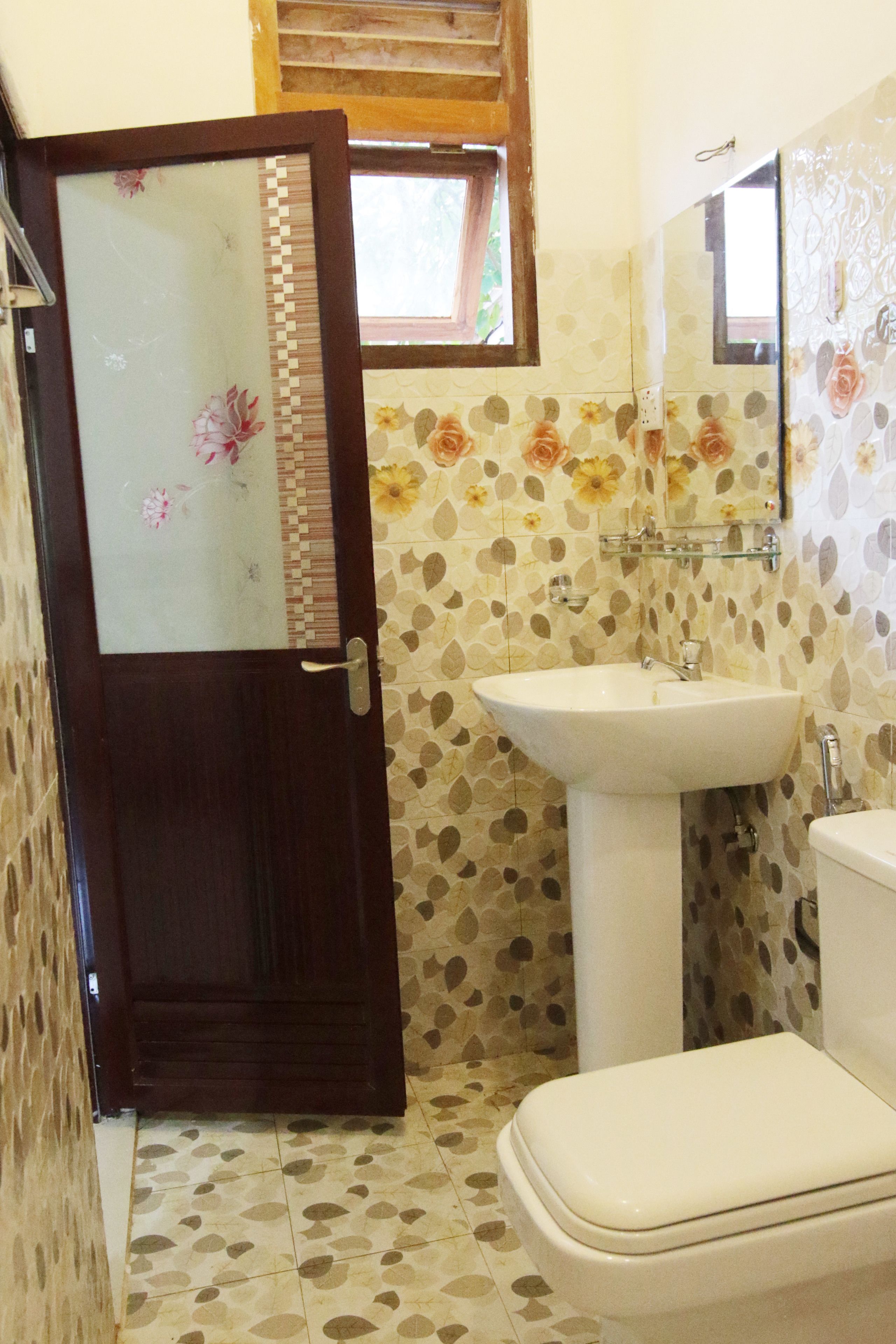 Une salle de bain avec une porte en bois, un lavabo et des toilettes.
