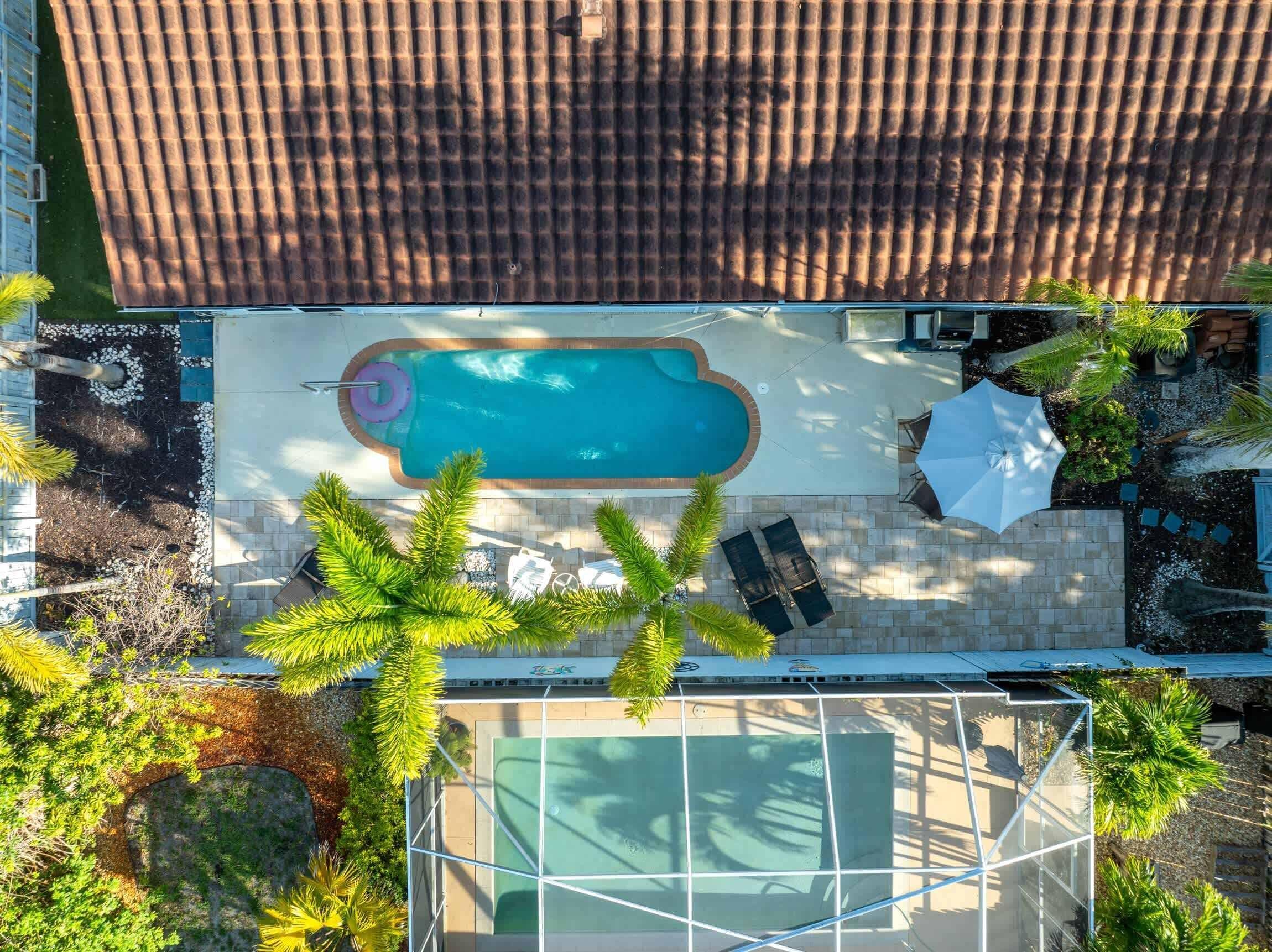 Une piscine sur le toit offrant une vue dégagée sur les environs, avec notamment une terrasse couverte et un espace clos par des parois de verre.