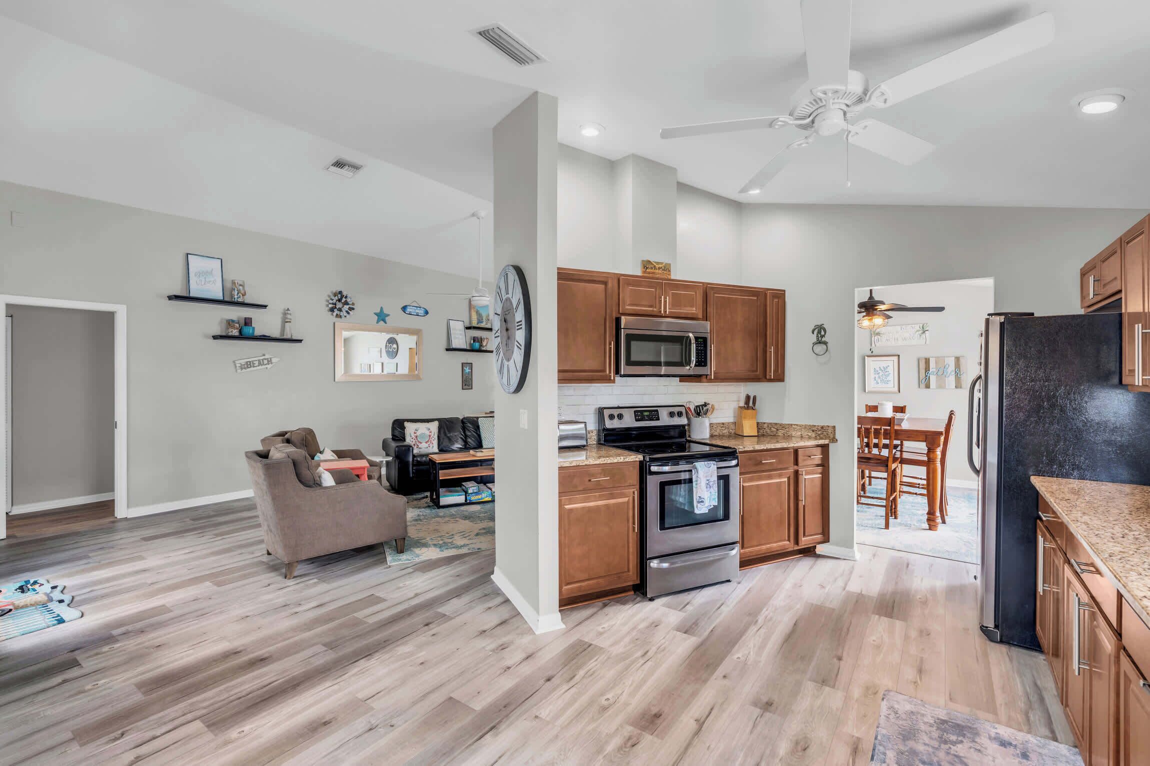 A modern kitchen with wooden cabinets, a stainless steel oven, and a microwave.