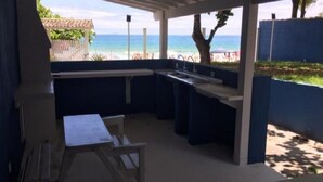Un área de cocina al aire libre con vista a la playa y al océano.