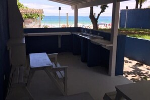 Relax on the patio with a view of the beach, surrounded by comfortable seating and a tranquil atmosphere.