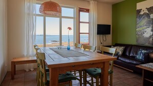 A dining area with a table and chairs, a sofa, and a TV.