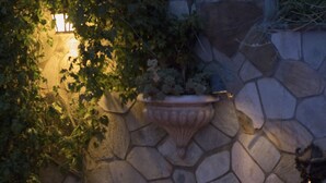 A stone wall with a built-in planter and a small fire feature.