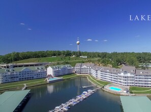 A lakeside hotel with multiple buildings, a dock with boats, and a tower in the background. - Parkview Bay Walk-in Level Condominium - Overlooks Pool, near Mall, Free Wi-Fi (Osage Beach)