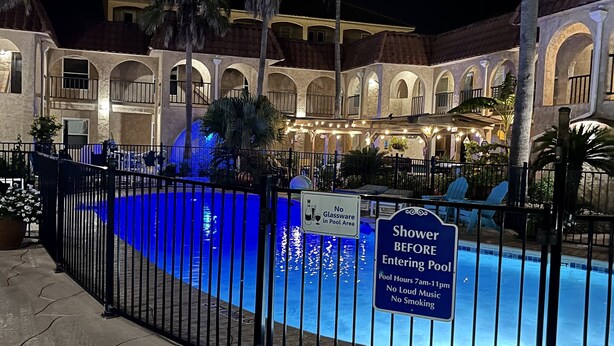 A pool area with a sign indicating no glassware in the pool and a shower area before entering the pool. - 2 BR 2 bath -  pool - 3 minute walk to beach! (Corpus Christi)