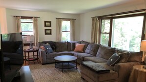 A living room with a sectional sofa, a coffee table, a TV, and a fireplace. - New photos with many updates! Bring your EV cord and adapter!  Walk to the fun! (Stonington)