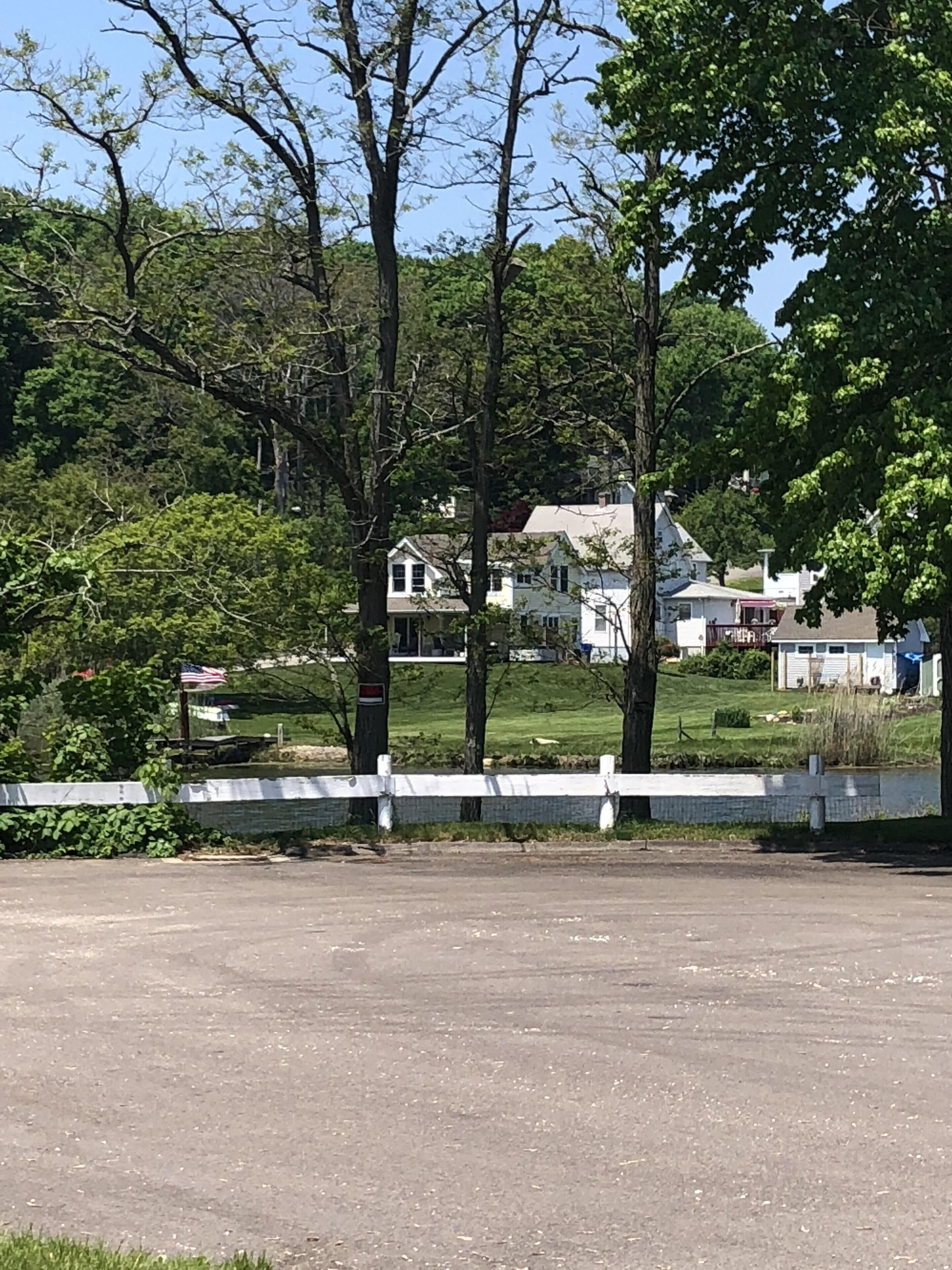 A residential area with houses, trees, and a paved road.