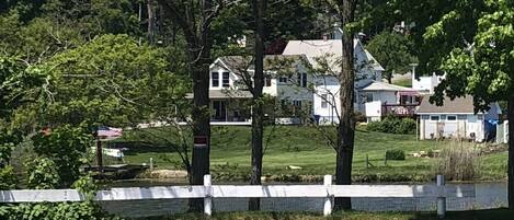 A residential area with houses, trees, and a paved road.