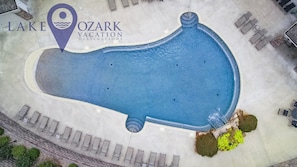 Eine Vogelperspektive auf einen Swimmingpool mit Liegestühlen und einem Schild für Lake Ozark Vacation Destinations.