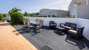 A patio with outdoor furniture, a table, and chairs.