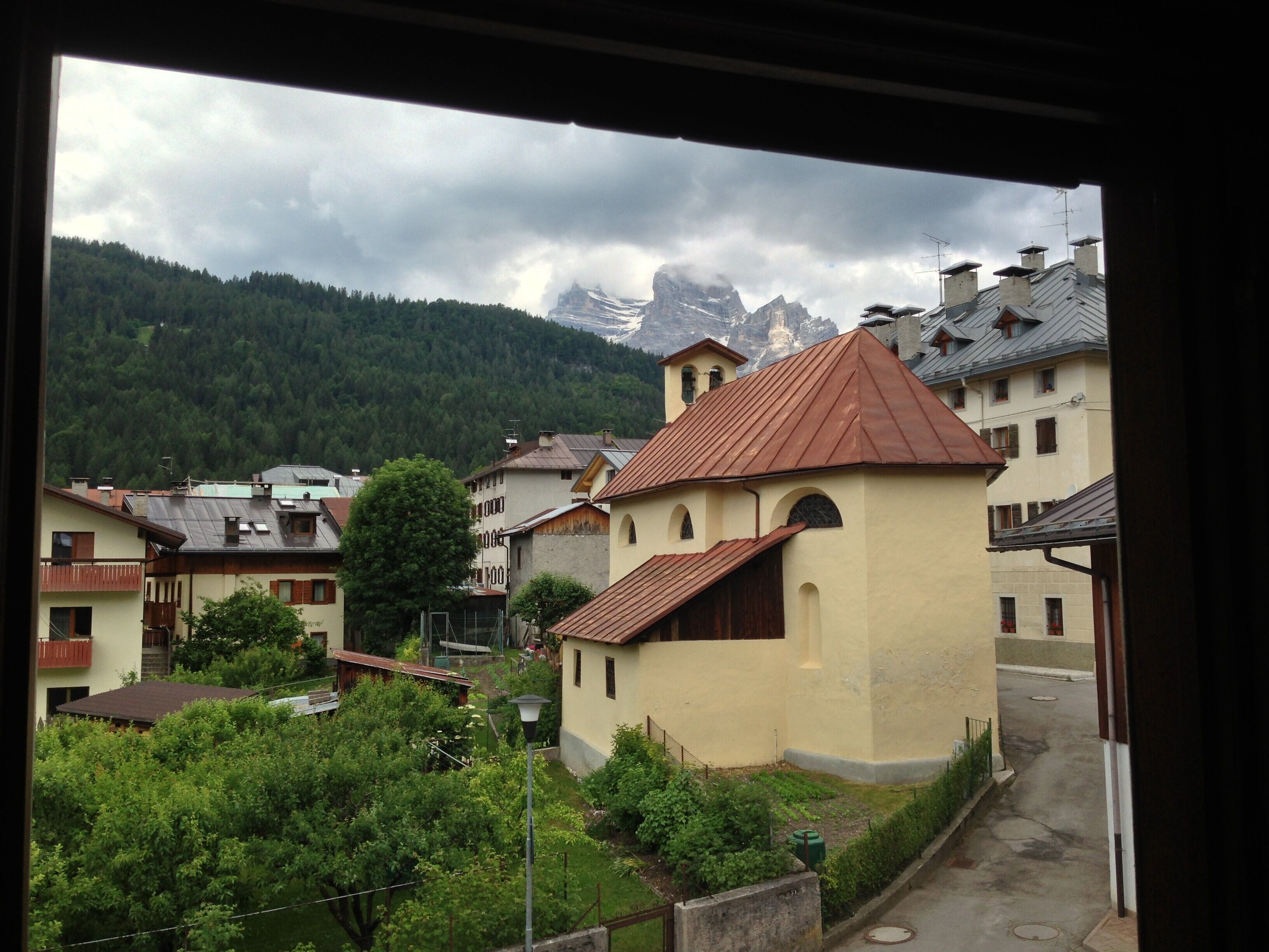 A residential area with houses, a street, and mountains in the background.
