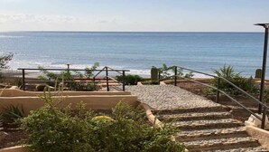 A staircase leading to a beach with a view of the ocean.