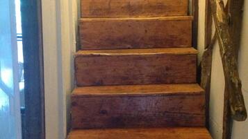 Un escalier en bois avec une main courante sur le côté droit.