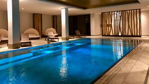 An indoor swimming pool with lounge chairs and a modern design. - Charming suite with pool-sauna area, spa-wellness area, restaurant. (Börgerende-Rethwisch)