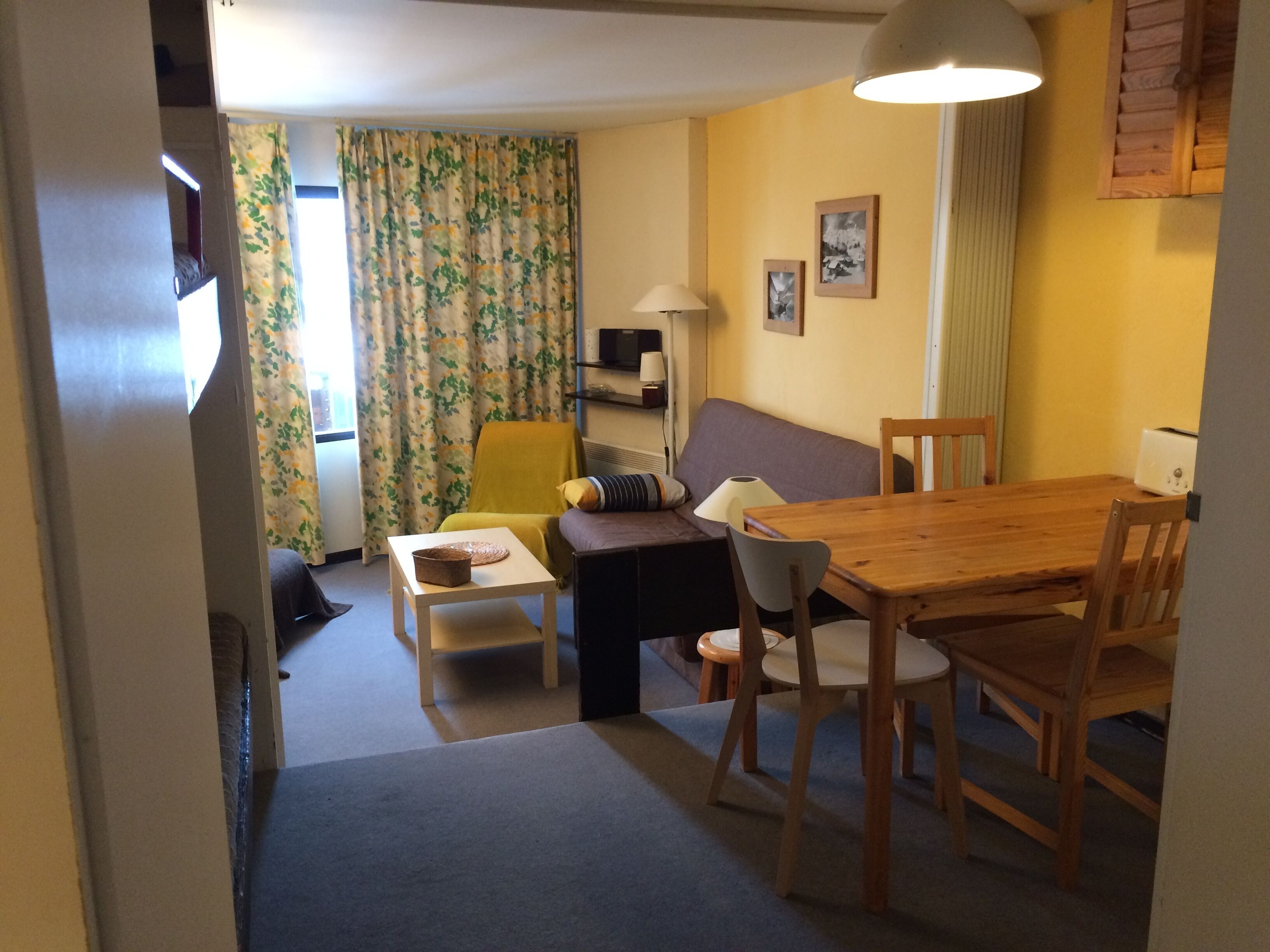A compact living space with a sofa, a dining table, and a small side table.