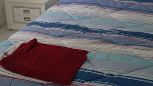 Un dormitorio con cama, mesita de noche y lámpara.